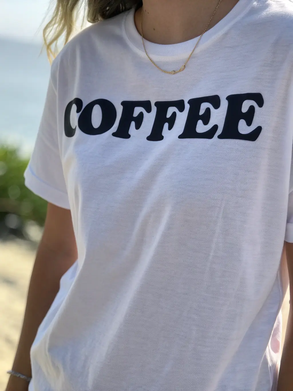 A Brooklyn Coffee House branded t-shirt with a minimalist design, hanging on a rack in a well-lit shop.